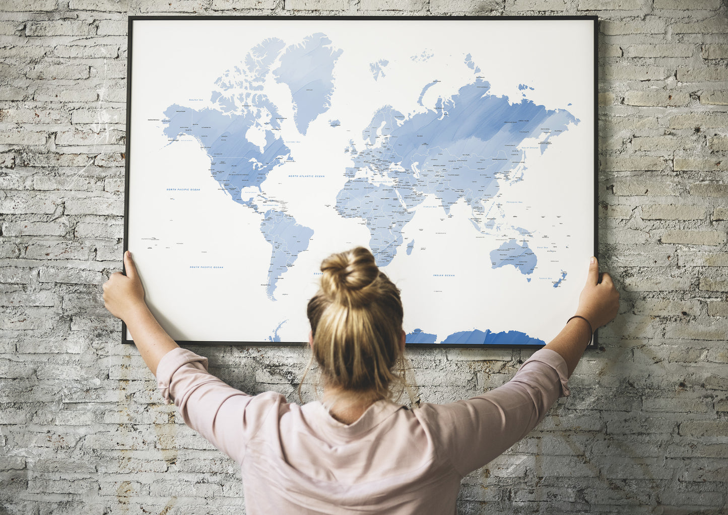 Blue watercolour world map large wall art in a black metal frame.