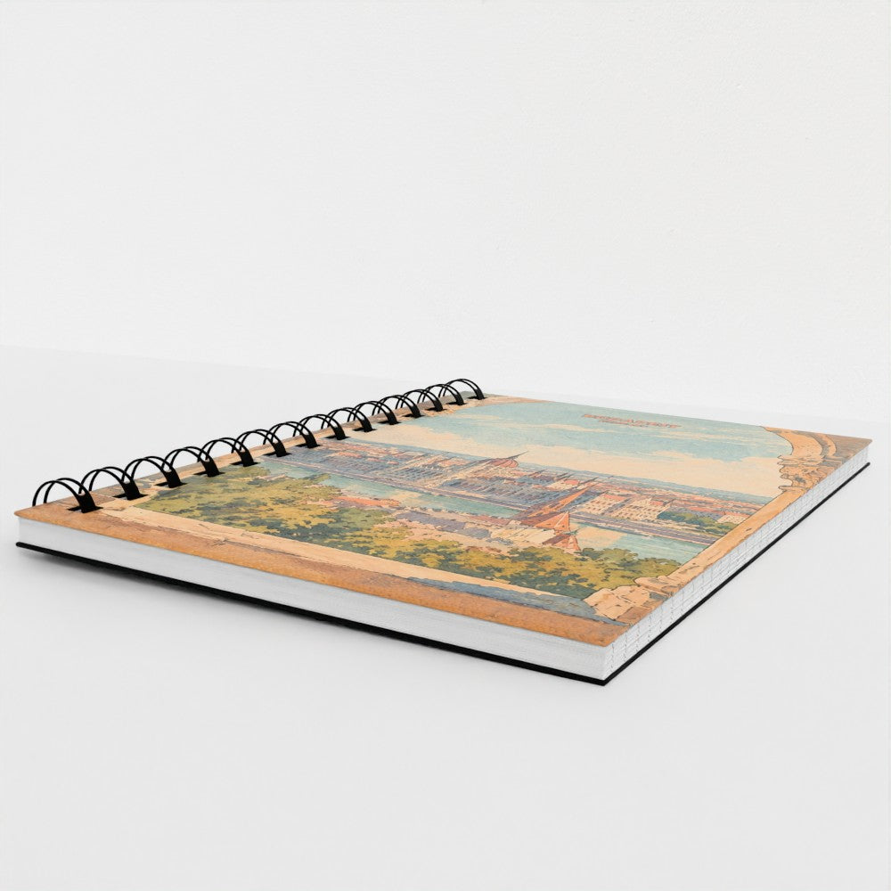 A spiral-bound notebook with a vintage-style scenic illustration on the cover, photographed on a clean white background.