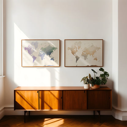 Two framed world maps hang on a white wall above a mid-century modern wooden sideboard with potted plants, in a sunlit room with herringbone wood flooring.