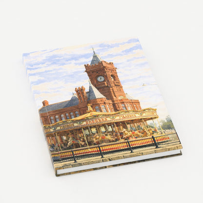 Notebook with a design of a clock tower and carousel on the cover
