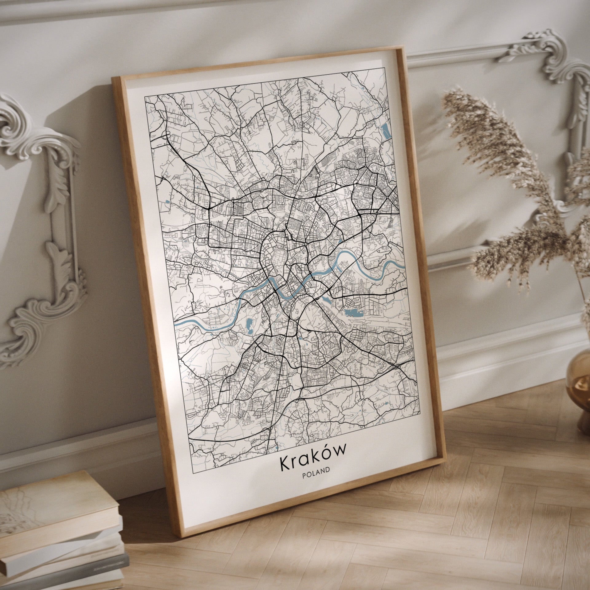 Framed map of Kraków on a wooden surface with decorative elements.