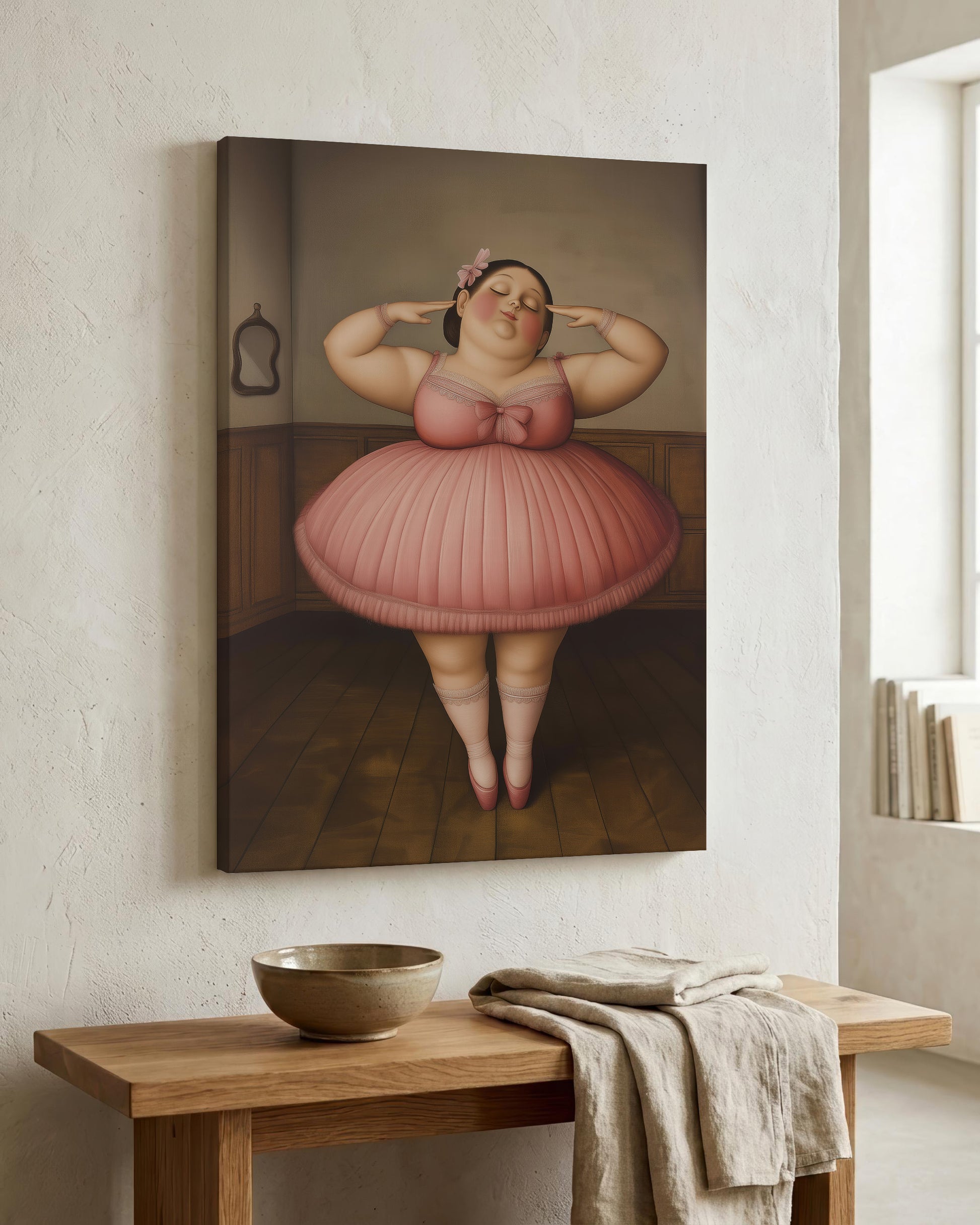 A vertical canvas wall art print depicting a stylized figure in a pink tutu standing in a room, displayed on a textured white wall above a wooden console table with a bowl and folded cloth.