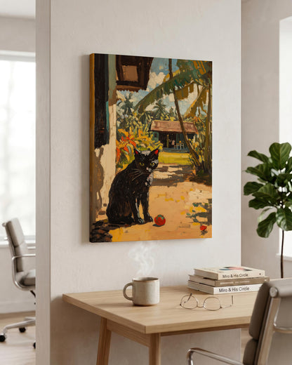 A vertical canvas wall art print depicting a black cat in a tropical garden courtyard, shown hanging on a white wall in a modern office setting above a wooden desk.