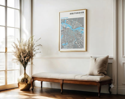 Framed map of Amsterdam on a wall above a wooden bench with a vase and flowers.