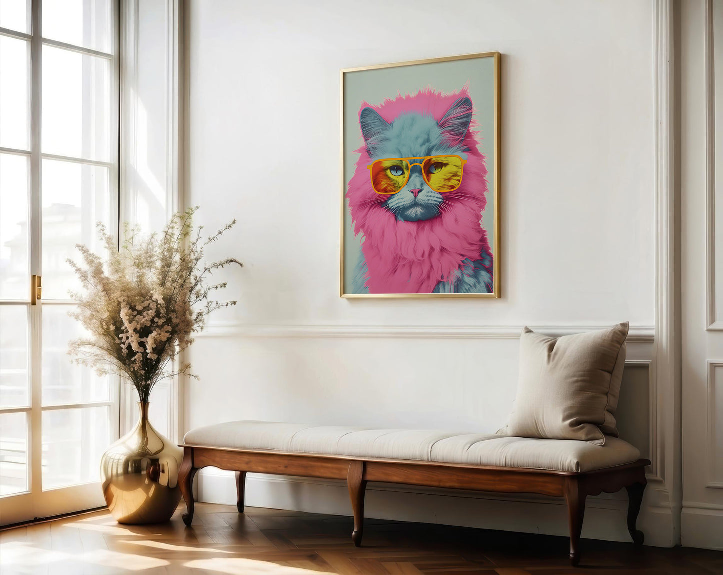 A framed art print of a fluffy cat wearing pink sunglasses hanging on a white wall above a wooden bench in a bright, modern room.