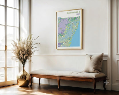 Framed map of Barcelona on a wall above a wooden bench with a vase and flowers.