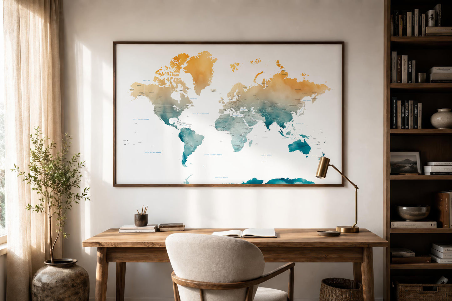 A framed world map poster with a watercolor design hangs on a wall above a wooden desk in a styled home office setting with a chair, lamp, and bookshelves.