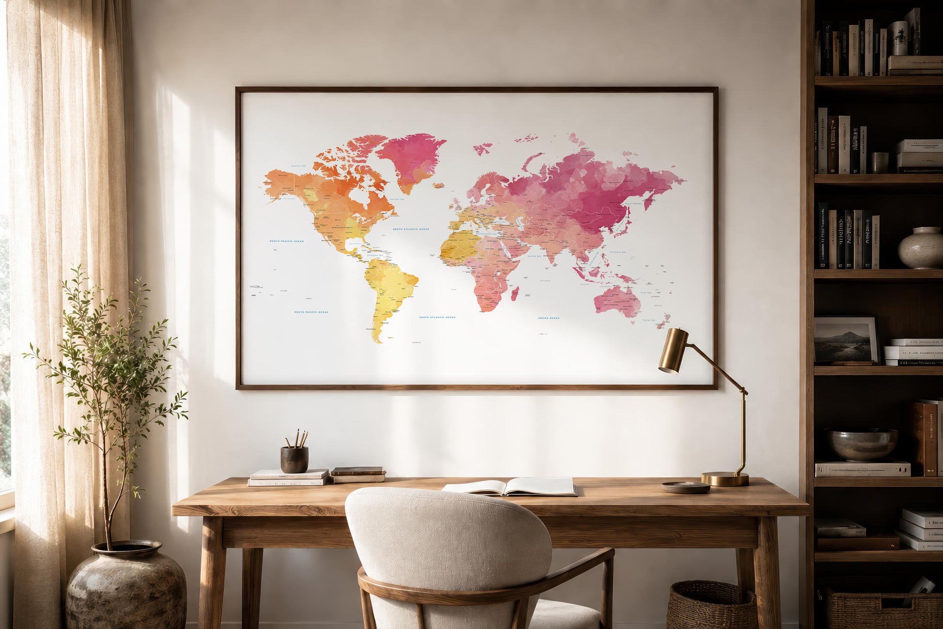 A framed world map poster with a colorful watercolor design hangs on a beige wall above a wooden desk in a styled home office setting.