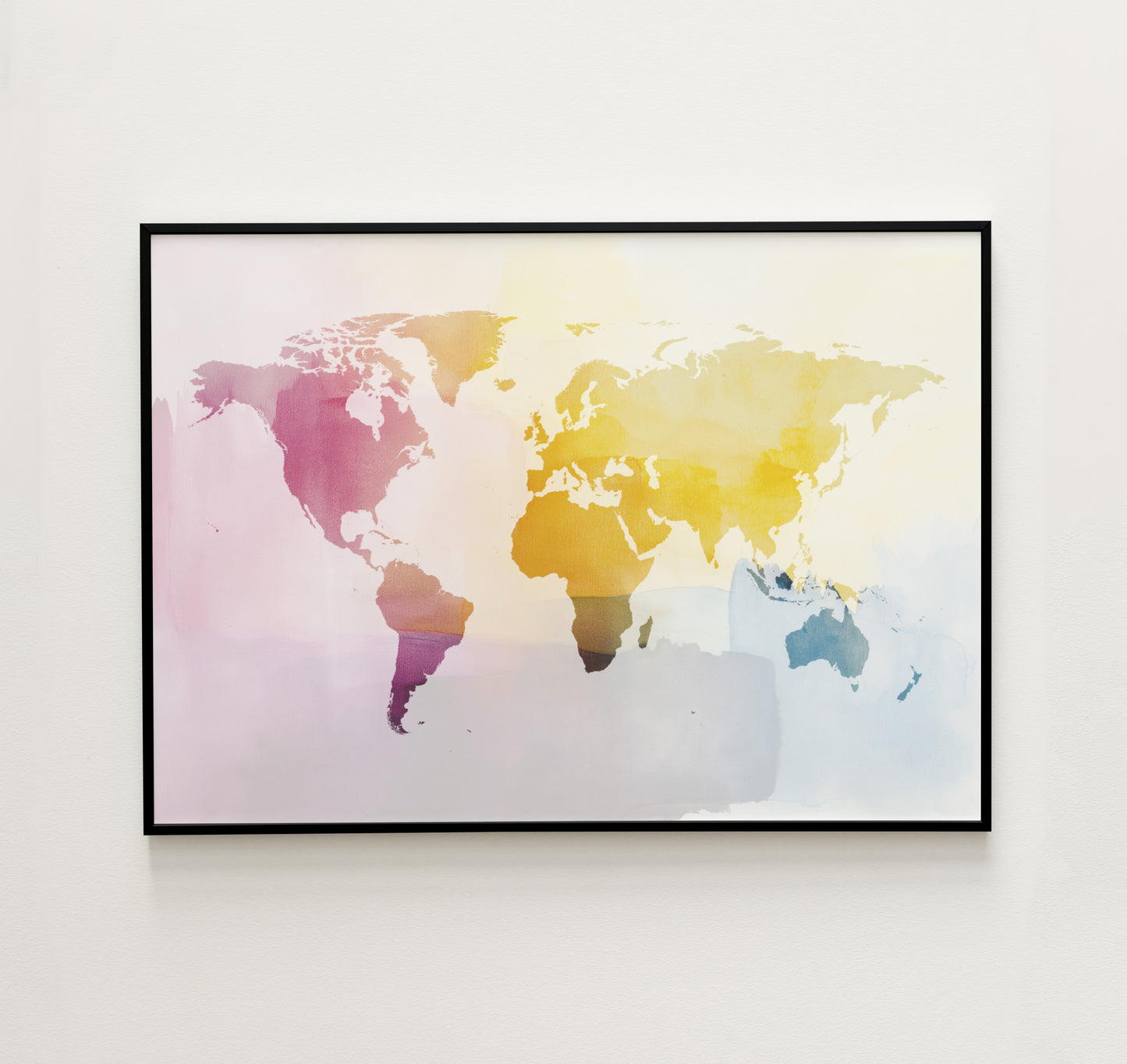 Framed world map art print with watercolor effect on a white wall