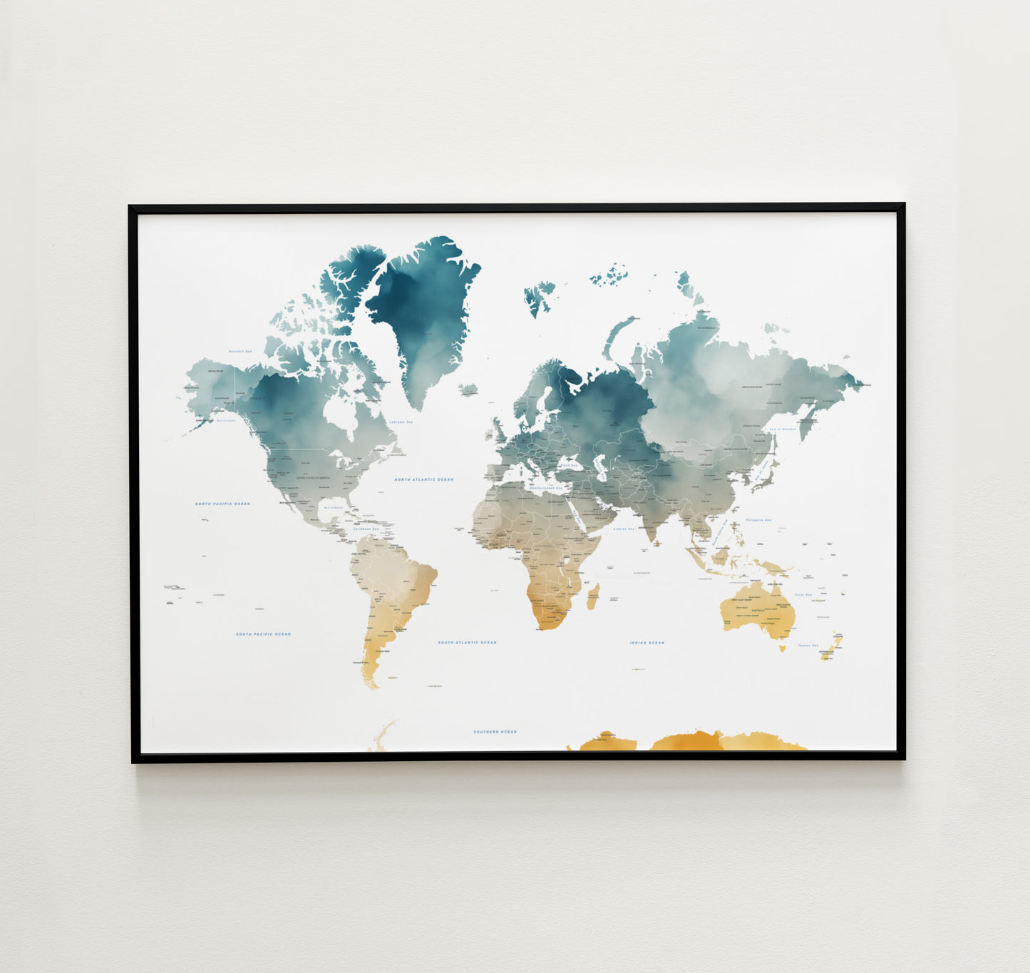 A framed world map art print with watercolor-style continents in teal, blue, beige, and gold tones, displayed on a light neutral wall.