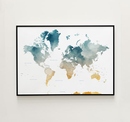 A framed world map art print with watercolor-style continents in teal, blue, beige, and gold tones, displayed on a light neutral wall.