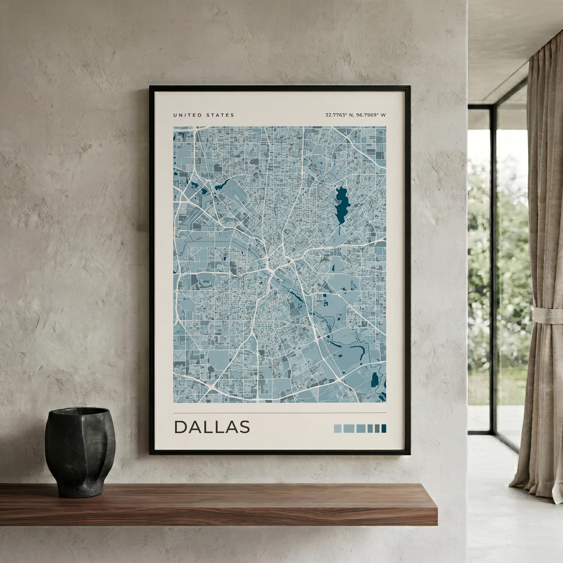 A blue Dallas city map print in a black wood frame above a shelf