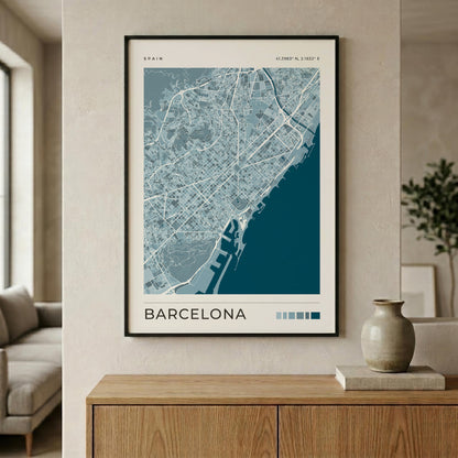A framed Barcelona city map poster with a blue and white design, hanging on a textured beige wall above a wooden console table in a modern living room setting.