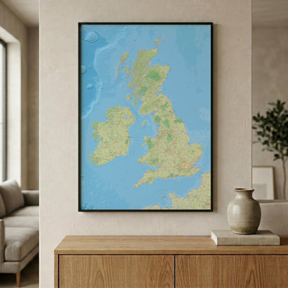A framed map of the United Kingdom and Ireland, featuring light blue oceans and green/beige landmasses, displayed on a beige wall above a wooden console table in a modern living room setting.