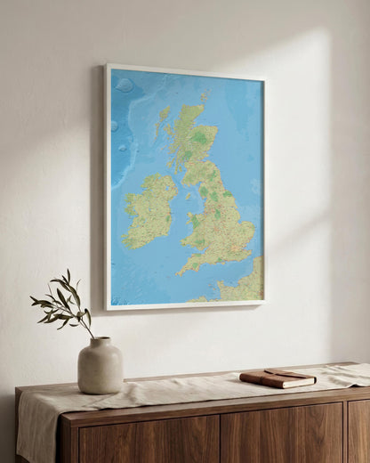 A framed map of the United Kingdom and Ireland hanging on a light-colored wall above a wooden console table with a vase and a book.