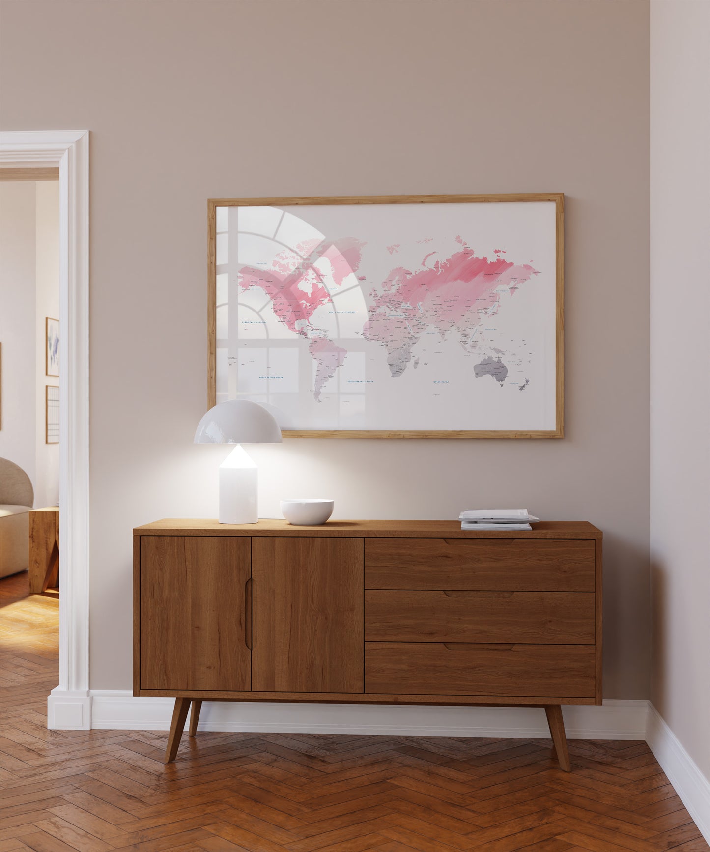 Pink watercolor world map print in a wood frame.