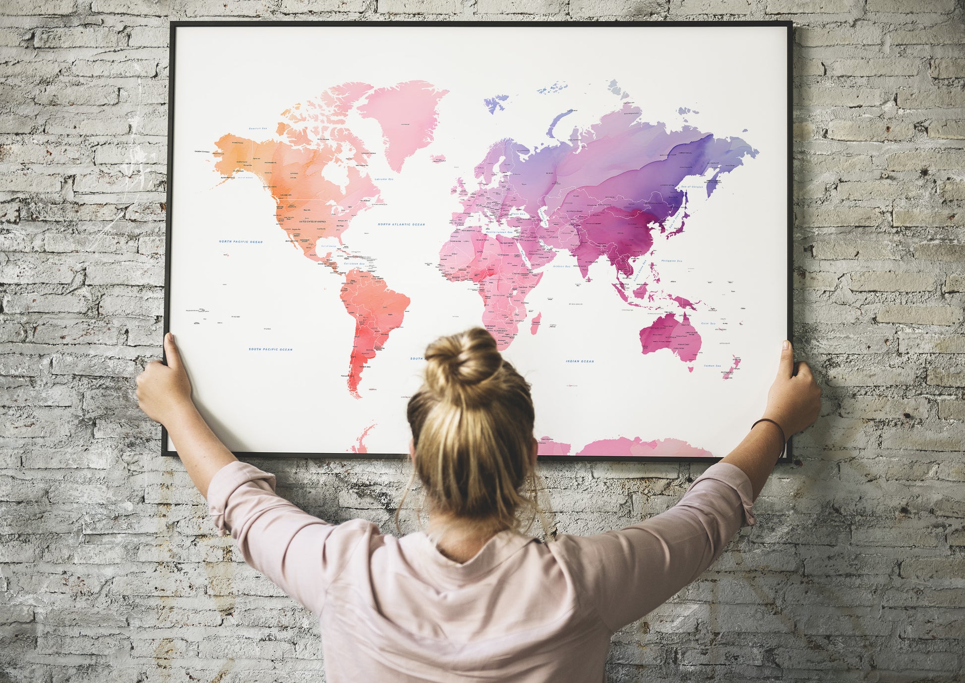 Colorful watercolour world map large wall art print in a black metal frame.