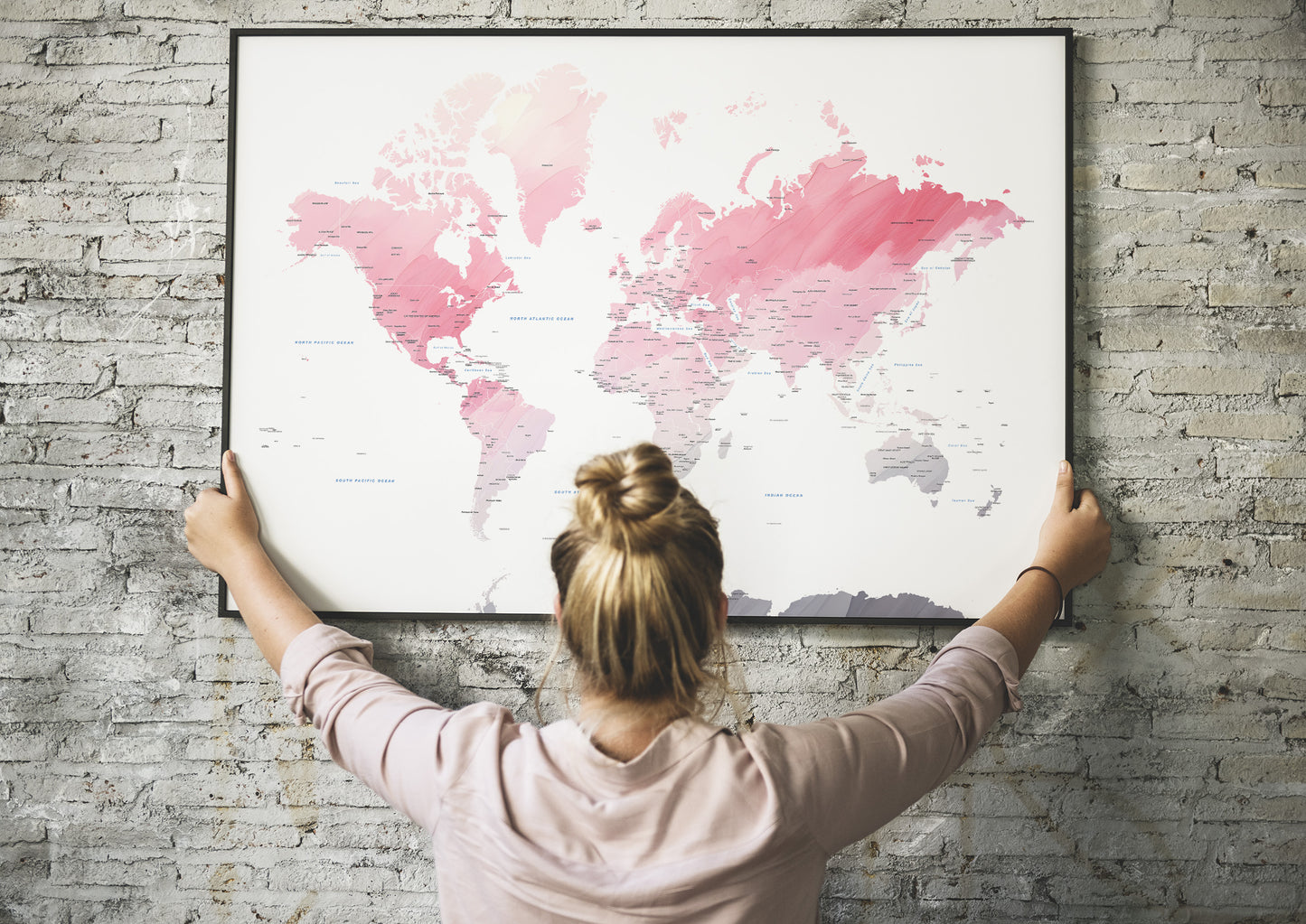 Watercolor world map print in a black metal frame.