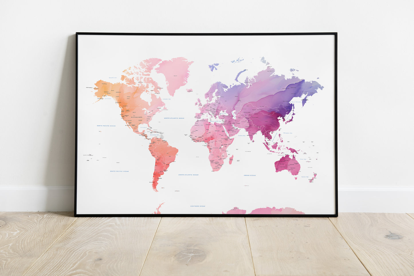 Colorful watercolour world map wall art print in a black metal frame.