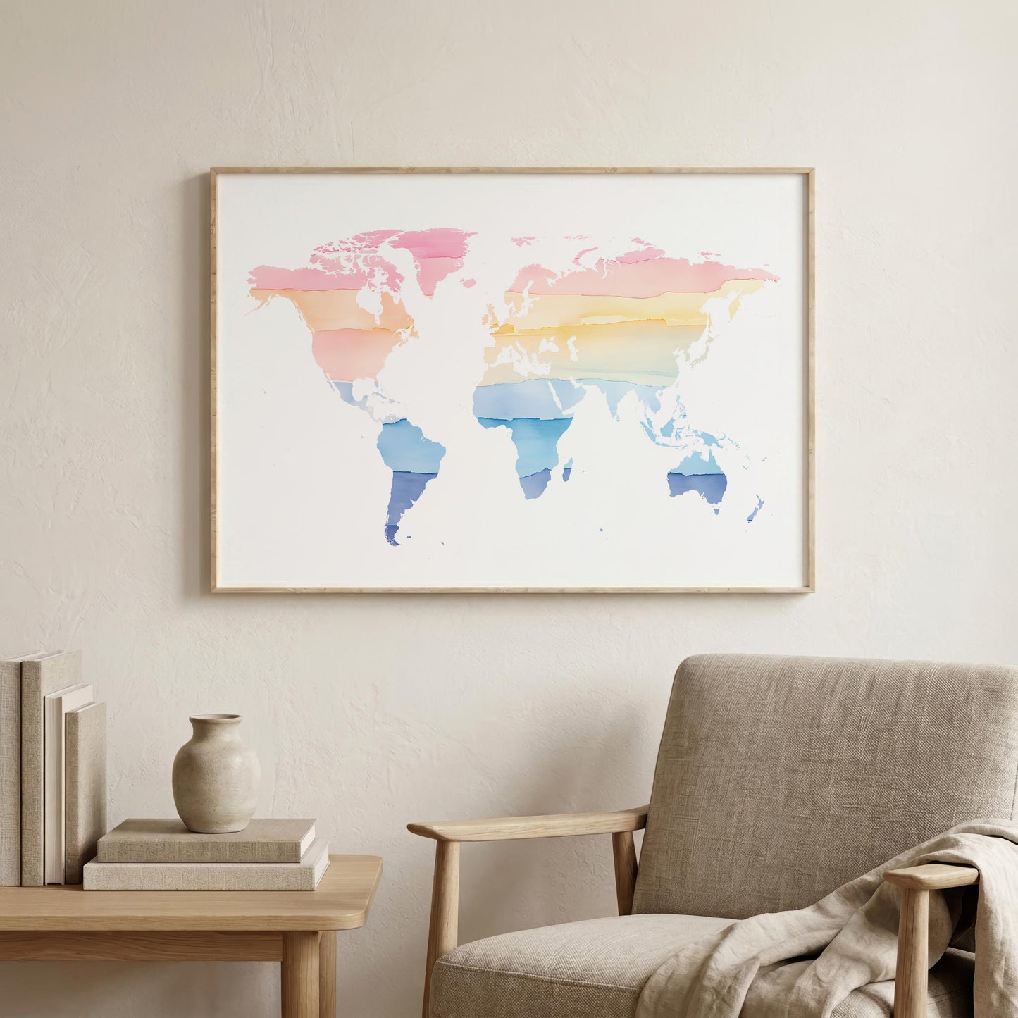 A framed world map art print with pastel watercolor stripes in pink, orange, yellow, and blue, displayed on a light beige wall above a modern armchair and side table.