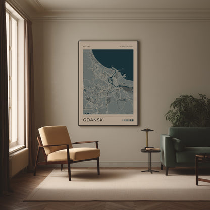 A framed minimalist city map print labeled GDANSK hangs on a beige wall in a styled living room with a cream armchair, green sofa, small side table, and window.