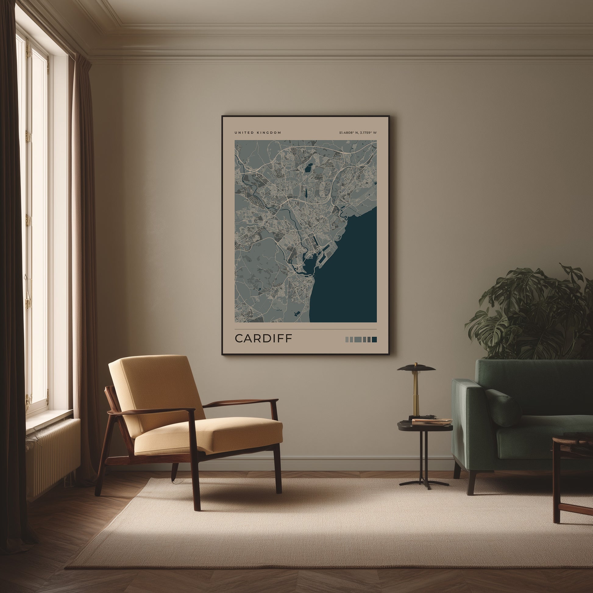 A framed art print of a Cardiff city map hangs on a beige wall in a styled living room with a cream armchair, a green sofa, and a small side table.
