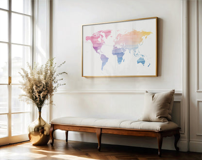 A framed world map art print with a gold frame hangs on a white wall above a wooden bench with a beige cushion in a bright, sunlit room.