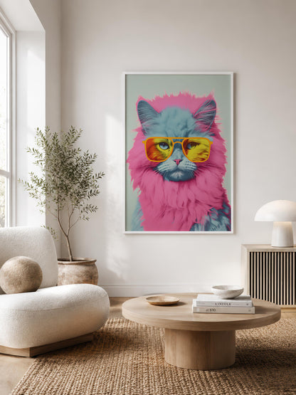 A framed pop-art poster of a fluffy cat wearing yellow sunglasses hanging on a light beige wall in a modern living room setting.