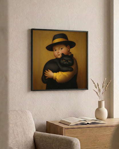 A framed art print hanging on a textured beige wall above a wooden console table. The print depicts a stylized portrait of a child wearing a black hat and holding a black cat against a warm gold background.