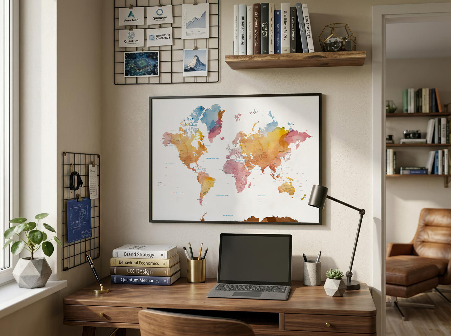 A framed world map poster with a colorful watercolor design hangs on a beige wall above a wooden desk in a styled home office setting.