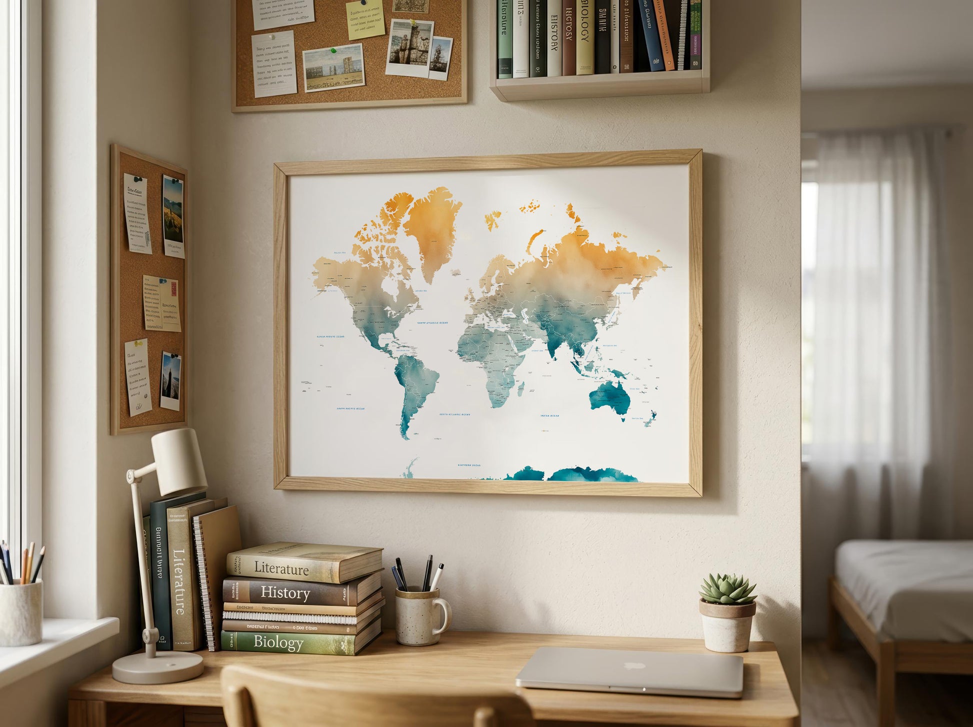 A framed world map poster with watercolor-style continents in orange, yellow, teal, and blue, displayed on a wall above a wooden desk in a bright, modern bedroom or study.