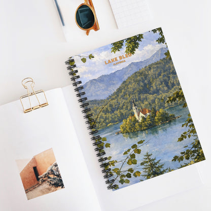 Notebook with a scenic cover of a lake and mountains on a white surface.