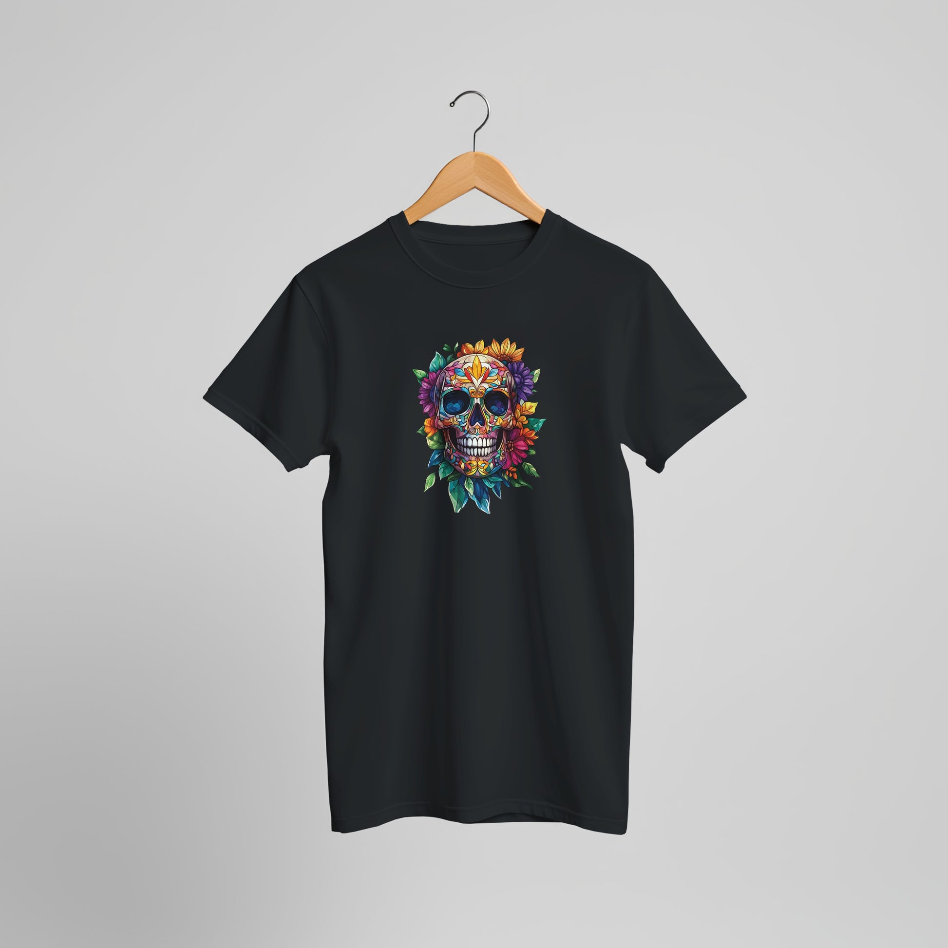 A black short-sleeve t-shirt hanging on a wooden hanger against a light gray background. The shirt features a colorful graphic of a sugar skull decorated with flowers and leaves on the center chest.