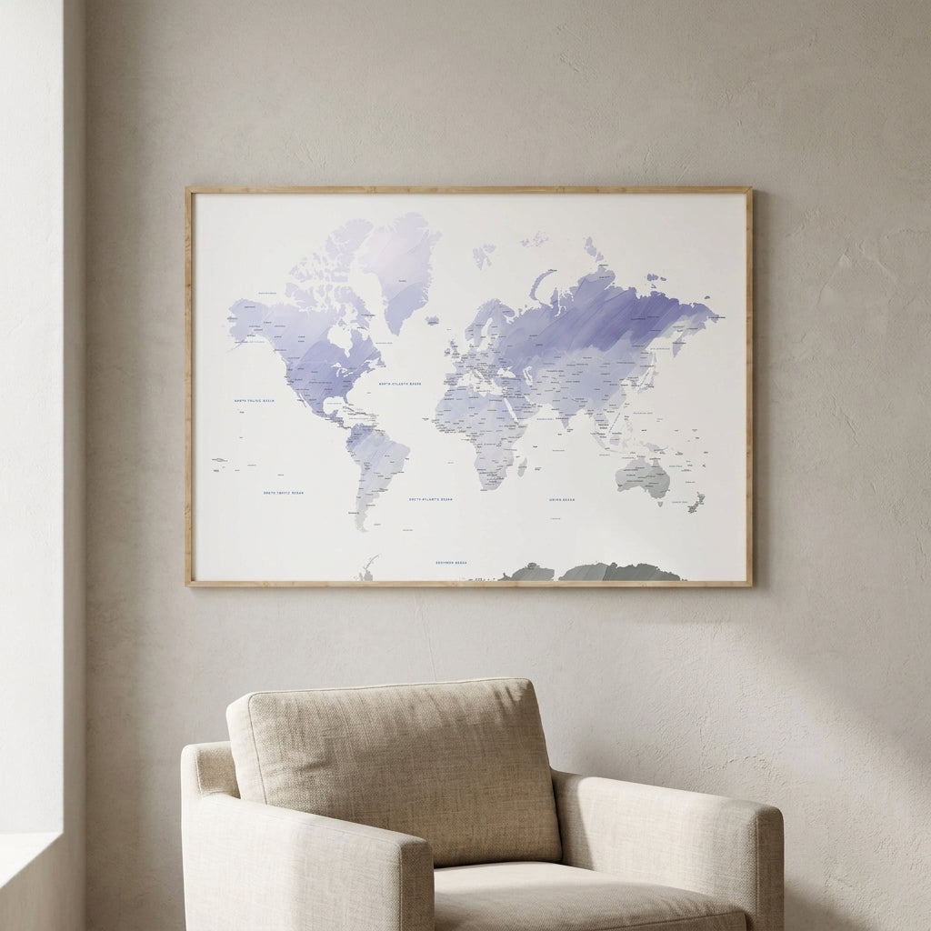 A framed world map print with watercolor-style blue and purple landmasses hangs on a light beige wall above a beige armchair in a softly lit room.