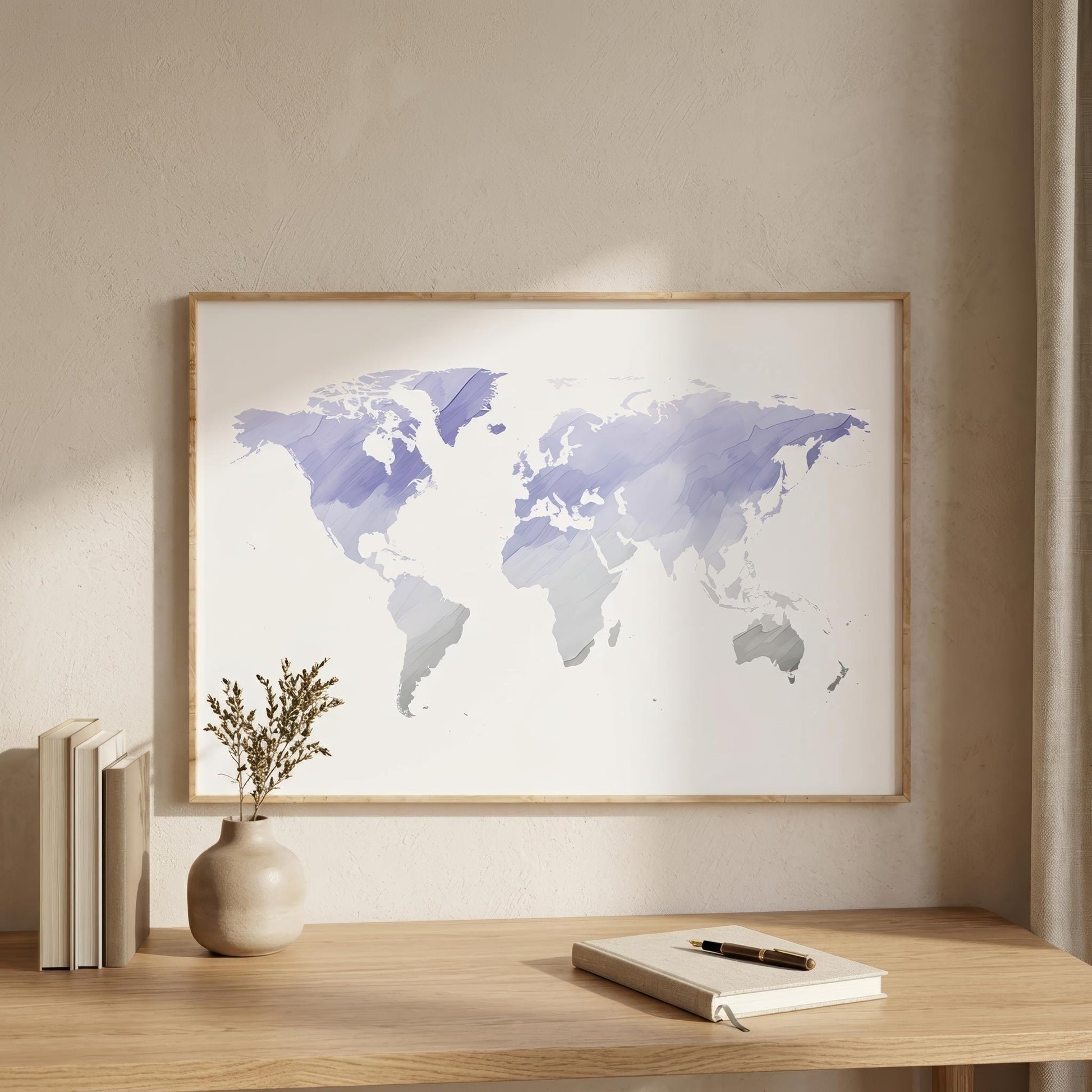 A framed world map art print with watercolor-style purple and blue continents on a white background, displayed on a light wood wall above a wooden desk with books, a vase, and a notebook.