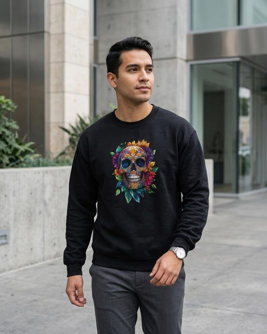 A man wearing a black crewneck sweatshirt with a colorful sugar skull graphic, standing outdoors in front of a modern concrete building.