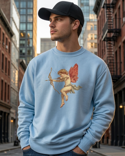 A man wearing a light blue crewneck sweatshirt with a graphic of Cupid on the front, standing in an urban street setting.