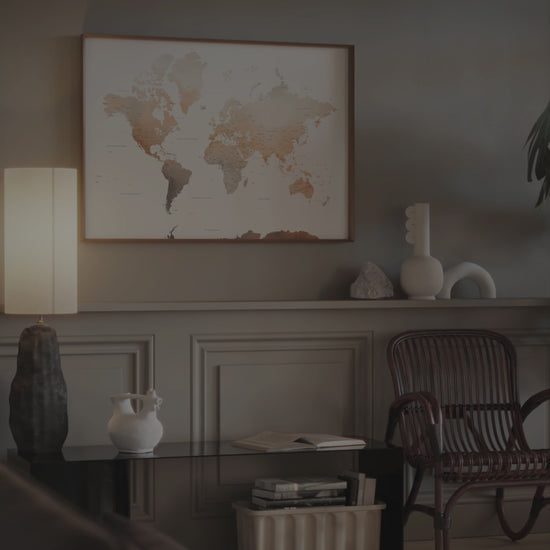 Watercolor World Map wall art in a dark wood frame.