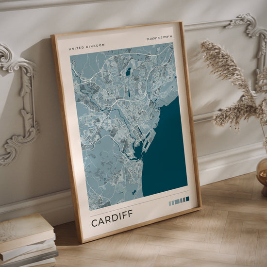 A Cardiff city map print in a wood frame on the floor