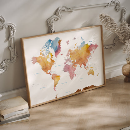 Orange and pink watercolor world map print in a wood frame