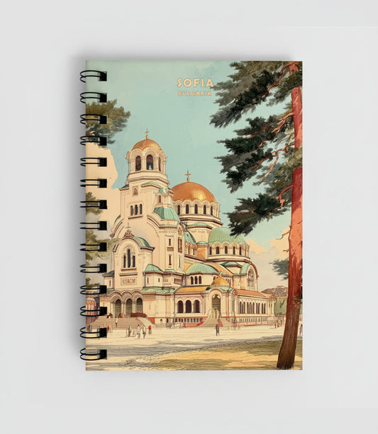 A spiral-bound notebook featuring a vintage-style travel illustration of the Sofia, Bulgaria cathedral with golden domes, green roofs, and a tree in the foreground. The cover reads 'SOFIA BULGARIA' at the top.