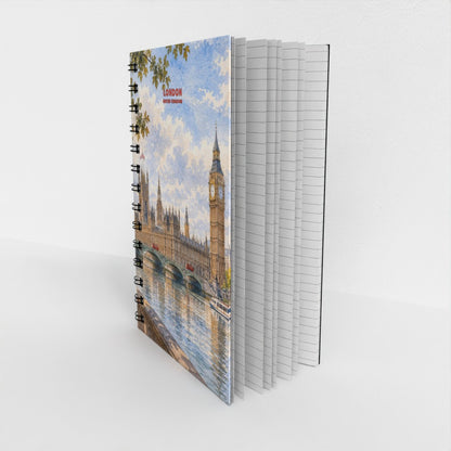A spiral-bound notebook standing upright, showing a printed cover illustration of London with Big Ben and the Houses of Parliament by the river. The notebook is photographed on a clean white studio background.