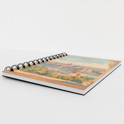 A spiral-bound notebook with a vintage-style scenic illustration on the cover, photographed on a clean white background.
