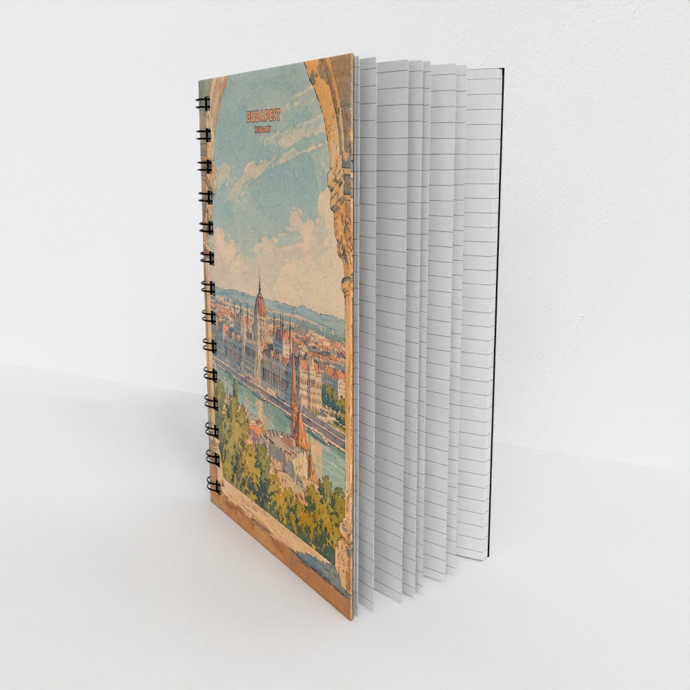 A spiral-bound notebook standing upright, showing a vintage-style scenic cover illustration of a city with towers and a river. The notebook has black spiral binding and white pages visible on the right side, photographed against a clean white background.
